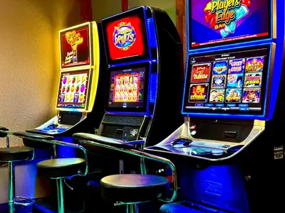 a row of slot machines in a casino with stools at Lacombe Motor Inn in Lacombe