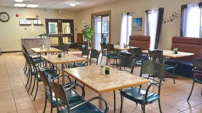 a restaurant with tables and chairs in a room at Lacombe Motor Inn in Lacombe