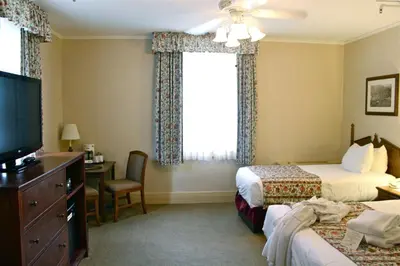 a hotel room with two beds and a television at Harrison Hot Springs Resort & Spa in Harrison Hot Springs