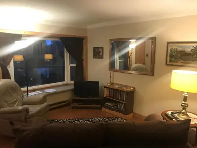 a living room with a couch and a tv and a window at Higgin's Inn in Powell River