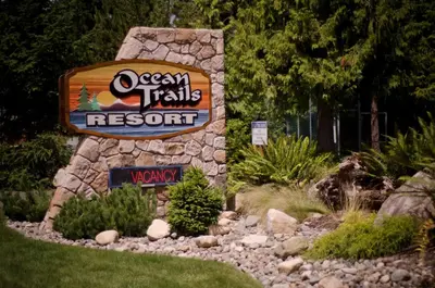 a sign for ausable trails resort in a garden at Ocean Trails Resort in Parksville