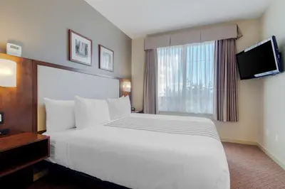 a hotel room with a large white bed and a window at Best Western PLUS Chemainus Inn in Chemainus