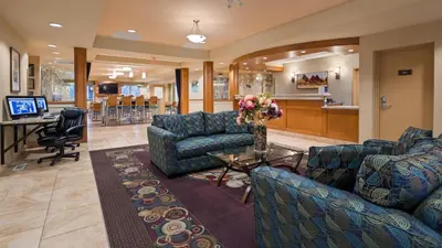 a waiting room with couches and a table with flowers at Best Western PLUS Chemainus Inn in Chemainus