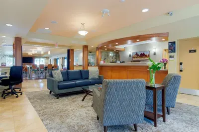 a lobby with chairs and a table and a bar at Best Western PLUS Chemainus Inn in Chemainus