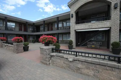 a building with potted plants and flowers in front of it at Canadas Best Value Inn-Prince George in Prince George