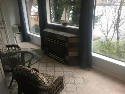 a living room with a table and two windows at Long Lake Waterfront Bed and Breakfast in Nanaimo