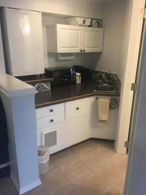 a kitchen with white cabinets and a sink at Long Lake Waterfront Bed and Breakfast in Nanaimo