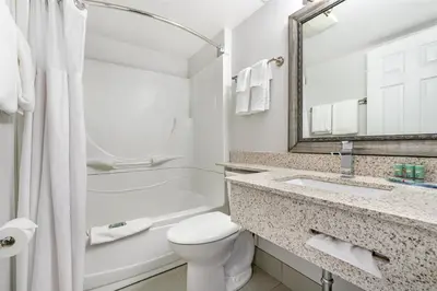 a bathroom with a toilet and a sink and a mirror at Best Western Prince George Downtown in Prince George