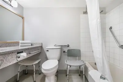 a bathroom with a toilet and a sink and a tub at Best Western Prince George Downtown in Prince George