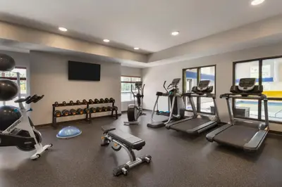 a gym with several treadmills and elliptical machines at Microtel Inn & Suites by Wyndham Oyster Bay Ladysmith in Ladysmith