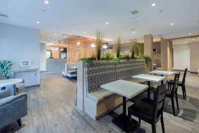 a restaurant with tables and chairs and plants at Microtel Inn & Suites by Wyndham Oyster Bay Ladysmith in Ladysmith