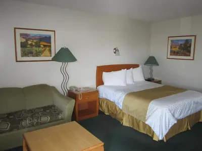 a hotel room with a bed and a couch at Ramada Merritt in Merritt