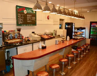 a bar in a restaurant with a row of stools at Johnston Canyon Lodge & Bungalows in Castle Junction