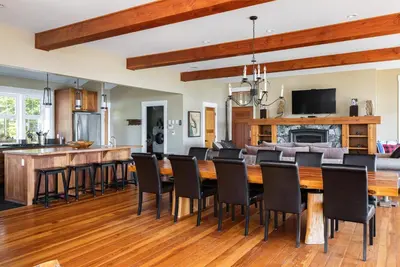 a kitchen and living room with a wooden table and chairs at Black Rock Beach House in Ucluelet