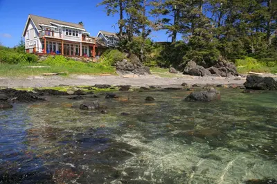 a house on the shore of a body of water at Black Rock Beach House in Ucluelet