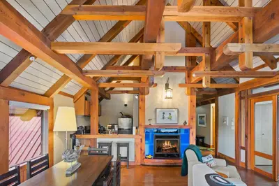 a living room with wooden ceilings and a fireplace at Black Rock Landing in Ucluelet