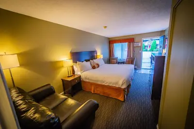 a hotel room with a bed and a couch at Alpine Inn & Suites in Nelson