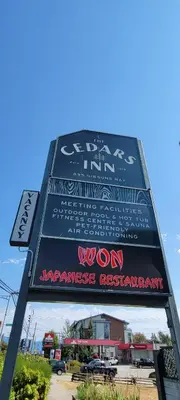 a sign with graffiti on the side of a building at The Cedars Inn Hotel & Convention Centre in Gibsons