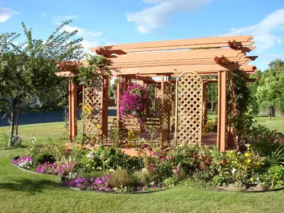 a gazebo with flowers in a garden at Canadas Best Value Inn Kelowna in Kelowna