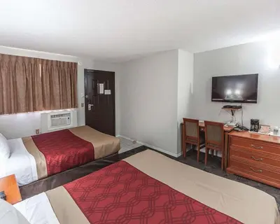 a hotel room with two beds and a desk at Econo Lodge Inn & Suites Drumheller in Drumheller