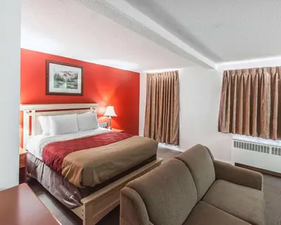 a hotel room with a bed and a couch at Econo Lodge Inn & Suites Drumheller in Drumheller
