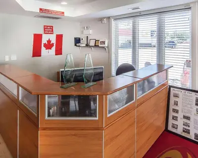 an office cubicle with a wooden counter with a window at Econo Lodge Inn & Suites Drumheller in Drumheller