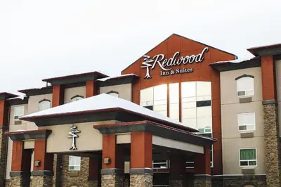 a hotel with a sign on the front of it at Redwood Inn & Suites in Clairmont