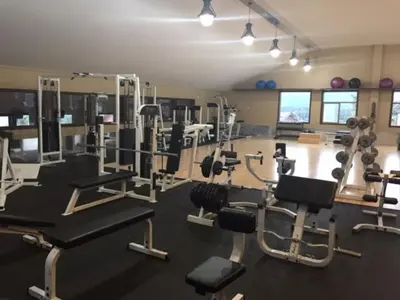 a gym with several treadmills and machines in a room at Spruce Hill Resort & Spa in 108 Mile Ranch