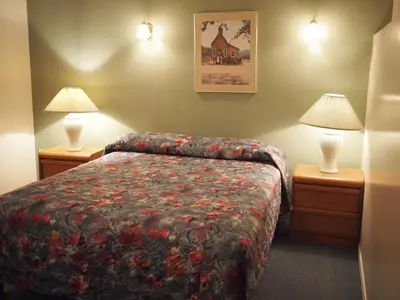 a hotel room with a bed and two lamps at Whale's Tail Guest Suites in Ucluelet
