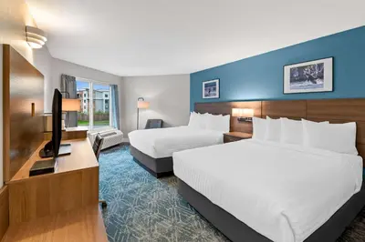 a hotel room with two beds and a flat screen tv at Hotel Feng, BW Signature Collection in Parksville