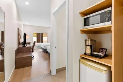 a room with a kitchen with a microwave and a living room at Hotel Feng, BW Signature Collection in Parksville