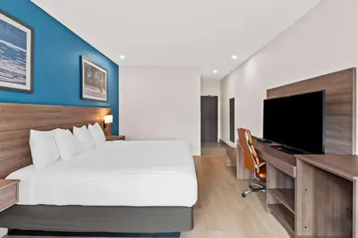 a bedroom with a bed and a desk with a television at Hotel Feng, BW Signature Collection in Parksville