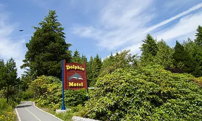 a sign for a mountain motel on the side of a road at Dolphin Motel in Tofino