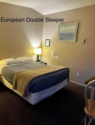 a bed in a hotel room with acknowledgment double sleeper at West Coast Motel on the Harbour in Ucluelet