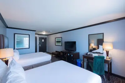 a hotel room with two beds and a television at Prestige Treasure Cove Resort in Prince George