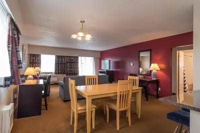a dining room and living room with a table and chairs at Port Augusta Inn in Comox