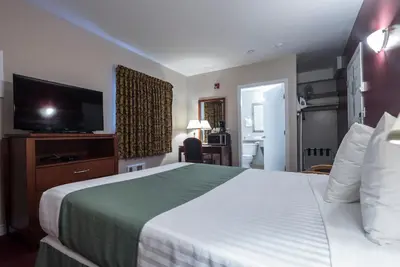 a hotel room with a bed and a flat screen tv at Port Augusta Inn in Comox