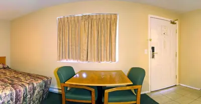 a room with a table and chairs and a bed at Travelodge by Wyndham Merritt in Merritt