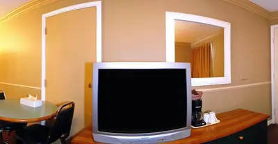 a television sitting on top of a table with a mirror at Travelodge by Wyndham Merritt in Merritt