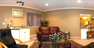 a living room with a leather chair and a table at Travelodge by Wyndham Merritt in Merritt