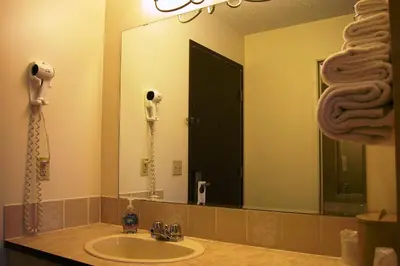 a bathroom with a sink and a large mirror at Best Seven Inn in Claresholm