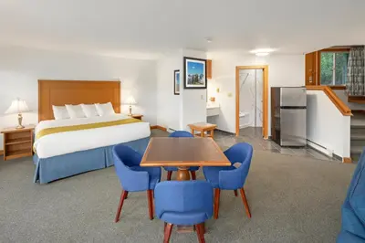 a hotel room with a bed and a table and chairs at Canadian Princess Lodge & Marina in Ucluelet