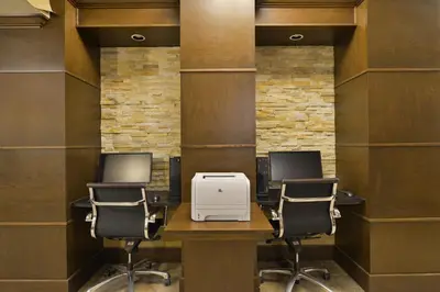a office with three chairs and a desk with a printer at Prestige Vernon Hotel in Vernon