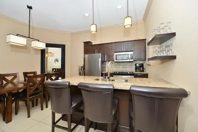 a kitchen and dining room with a counter and chairs at Prestige Vernon Hotel in Vernon