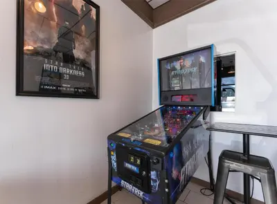 a video game machine in a room with a table at Prestige Harbourfront Resort, WorldHotels Luxury in Salmon Arm