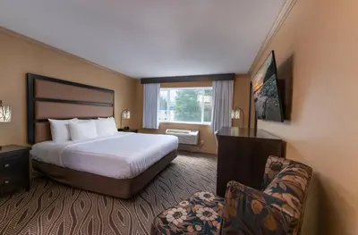 a hotel room with a bed and a chair at Prestige Golden Hotel in Golden