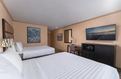 a hotel room with two beds and a desk at Prestige Golden Hotel in Golden