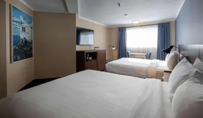 a hotel room with two beds and a television at Prestige Mountain Resort Rossland in Rossland