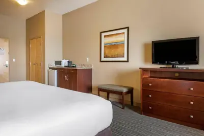 a hotel room with a bed and a flat screen tv at Quality Inn & Suites in Rimbey