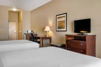 a hotel room with two beds and a flat screen tv at Quality Inn & Suites in Rimbey